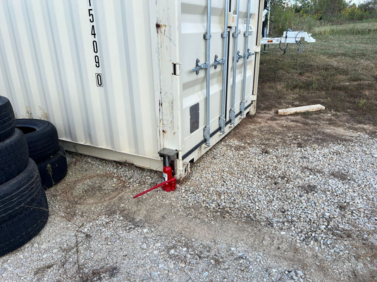 EZY Lift in use leveling a shipping container with a red bottle jack (bottle jack not included).