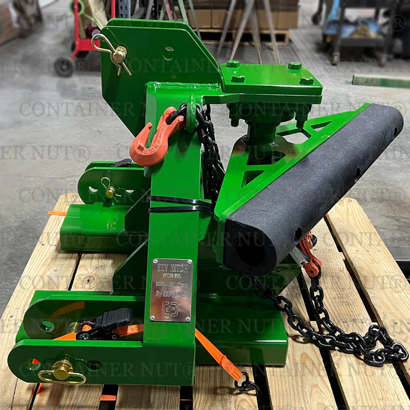 Load image into Gallery viewer, An EZY Hitch, branded by Container Nut, featuring various mechanical components, chains, and hooks in green is situated on a pallet in a shop. Logos and text reading &quot;CONTAINER NUT&quot; are partially visible on the bottom right.
