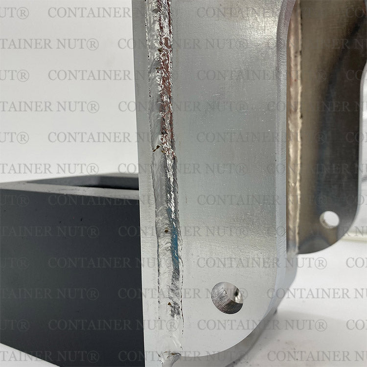 Load image into Gallery viewer, Close-up of an HD EZY Lift metallic part with visible weld seams and bolt holes. The background features a repeating watermark text &quot;Container Nut®&quot;. The surface of the metal exhibits a reflective texture with varying color tones.
