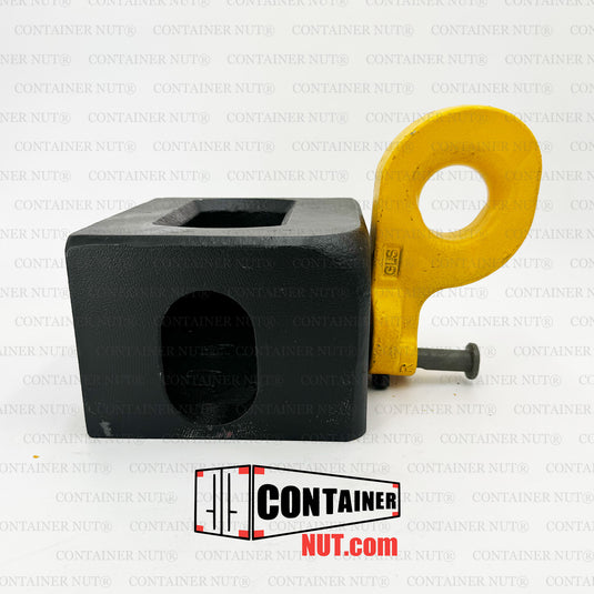 A Bottom Lifting Lug from Container Nut. A ISO corner casting has a smooth, rounded yellow hook attached to one corner. The corner casting includes a rectangular hole on the top side and a circular hole on the front side. The hook is designed to pivot from the corner, indicating its mechanical purpose.