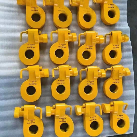 A grid of yellow Bottom Lifting Lugs by Container Nut arranged in five rows on a white surface. Each lifting lug features a round hole with a hook mechanism and has text inscribed on the top part.